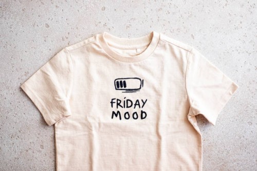 close-up of beige t-shirt with a print “friday mood” on light background, top view - fashion stock pictures, royalty-free photos & images