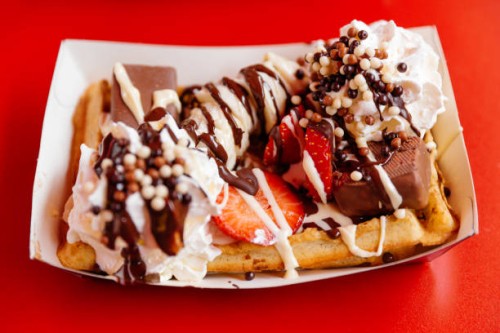 close-up of belgian waffle with strawberry, banana, cream and chocolate toppings - junk food stock pictures, royalty-free photos & images