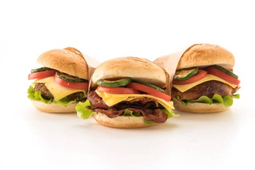 close-up of burgers against white background - junk food stock pictures, royalty-free photos & images