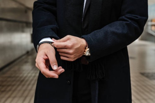 close-up of man's hands adjusting jacket sleeves in a modern urban setting. - fashion stock pictures, royalty-free photos & images