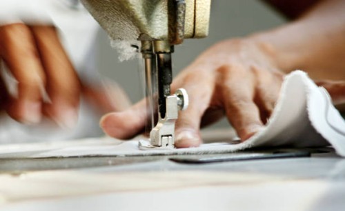 close-up of man worker sewing clothing in garment factory - fashion stock pictures, royalty-free photos & images