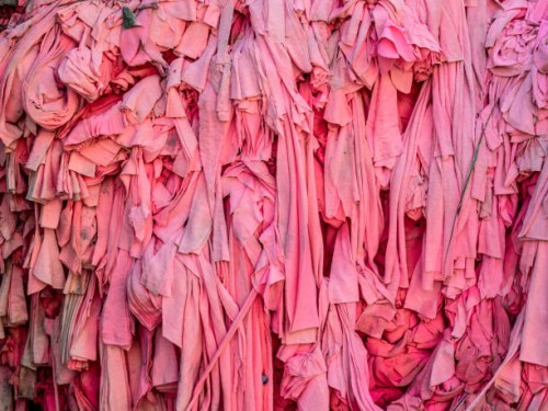 close-up of pile of scraps of pink fabric to be recycled at a textile plant. - fashion photos et images de collection