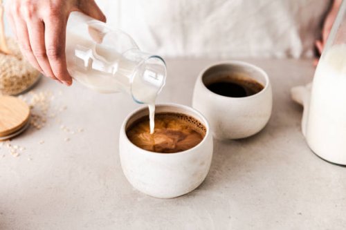 close-up of pouring oat milk into a black coffee c - coffee stock pictures, royalty-free photos & images