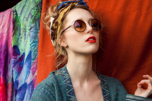 close-up of thoughtful stylish woman wearing sunglasses against fabric - fashion stock pictures, royalty-free photos & images