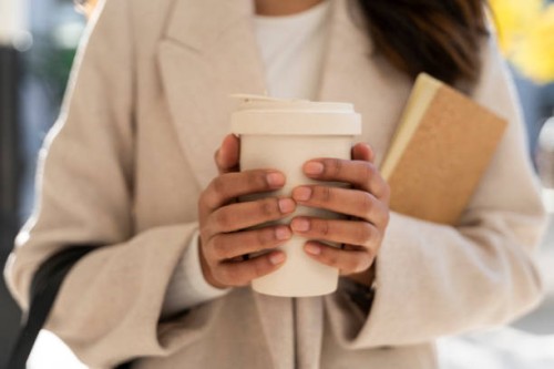 close-up of woman holding takeaway coffee - junk food stock pictures, royalty-free photos & images