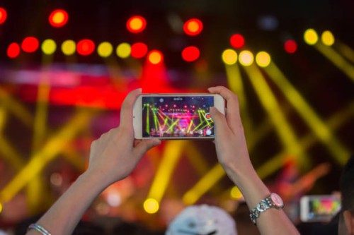 close-up of woman photographing music concert - concert stock pictures, royalty-free photos & images