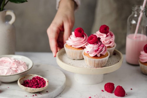 close-up of woman with delicious raspberry cupcakes in kitchen - home decoration stock pictures, royalty-free photos & images
