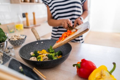 close-up of young woman with tablet cooking in kitchen at home - food stockfoto's en -beelden