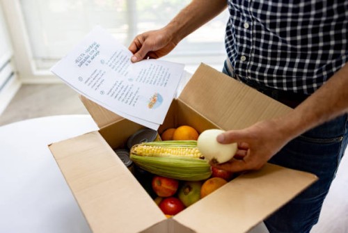 close-up on a man opening a food subscription box - food stock pictures, royalty-free photos & images