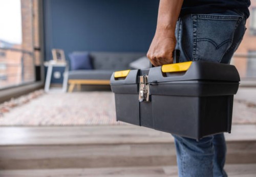 close-up on an electrician carrying a toolbox while working at a house - home decoration stockfoto's en -beelden
