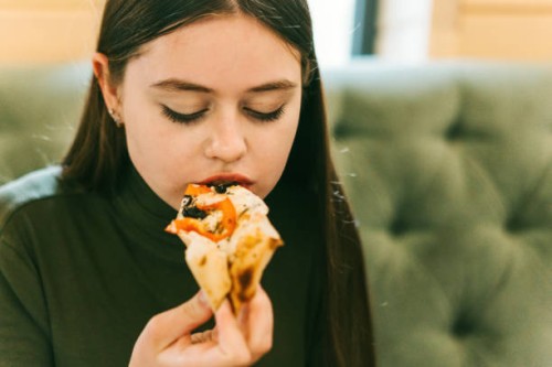 close-up portrait of a teenager girl eating pizza - junk food stock pictures, royalty-free photos & images