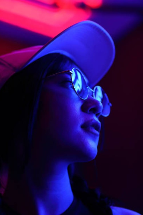 close-up portrait of young woman wearing sunglasses in darkroom - fashion stock pictures, royalty-free photos & images