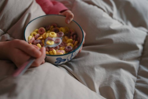 close-up view of an unrecognisable caucasian girl, eating a bowl of cereal for breakfast in bed after waking up. - junk food stock pictures, royalty-free photos & images