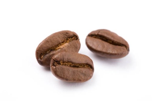 close up of coffee beans against white background - coffee stock pictures, royalty-free photos & images