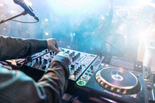 close up of dj hands controlling a music table in a night club. night club, nightlife concept. dj hands hold microphone and mixing dj remote. neon light. - concert stock pictures, royalty-free photos & images