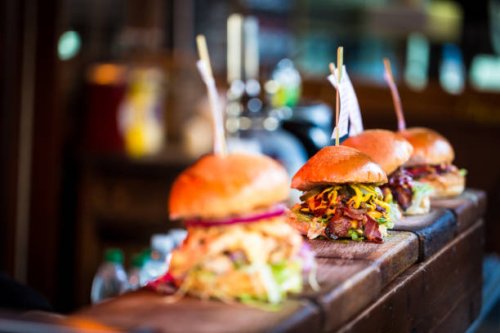 close up of fresh flame grilled burgers displayed in a row at food market - junk food stock pictures, royalty-free photos & images