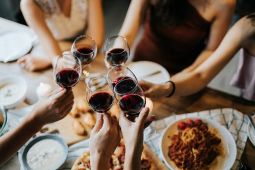 close up of happy young friends having fun and toasting and celebrating with red wine during party - food stock pictures, royalty-free photos & images