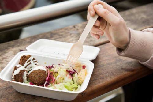 close up of healthy food in take away box, hand holding fork at urban market. - junk food stock pictures, royalty-free photos & images