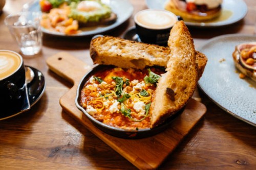 close up of shakshuka served in cooking pan on the table in cafe - food stockfoto's en -beelden