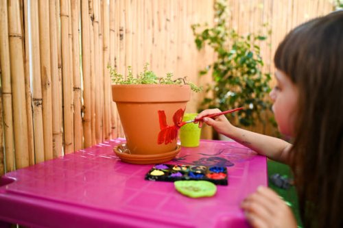 close up of terra-cotta pot with paintbrush. - garden decoration stockfoto's en -beelden