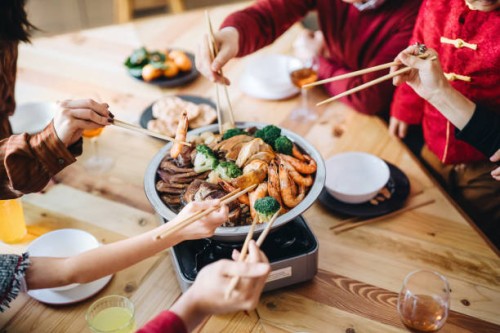 close up of three generations of joyful asian family celebrating chinese new year and enjoying scrumptious traditional chinese poon choi on reunion dinner - food stock pictures, royalty-free photos & images