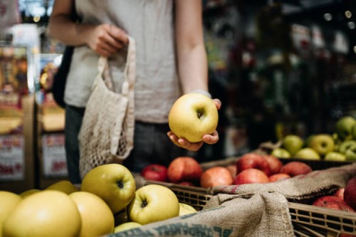 close up of young asian woman shopping for fresh organic fruits in farmer's market with a cotton mesh eco bag. environmentally friendly and zero waste concept - food stock pictures, royalty-free photos & images