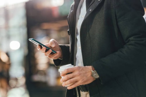 close up photo of man hands using a mobile phone outdoors - junk food stock pictures, royalty-free photos & images