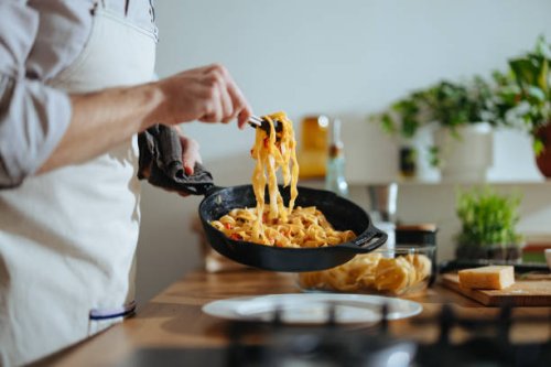 close up photo of man’s hands serving pasta with fresh vegetables - food stock pictures, royalty-free photos & images