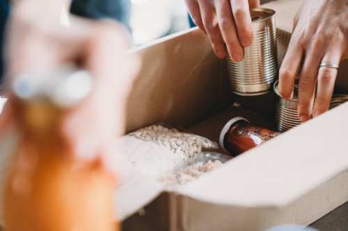 close up photo of volunteers preparing donation boxes with food at the food and clothes bank - food stock pictures, royalty-free photos & images