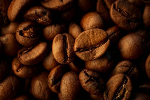 close up roasted coffee beans with dramatic light and copy space - coffee stock pictures, royalty-free photos & images