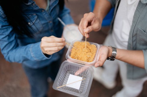 close up shot of an asian couple holding a box of local street food mochi - junk food stock pictures, royalty-free photos & images