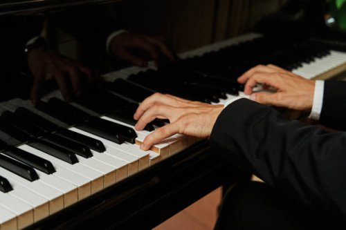 close up shot of the hands of an unrecognizable elegant pianist dressed in a suit playing a grand piano. - concert stock pictures, royalty-free photos & images
