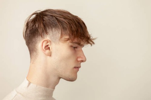 close up studio portrait of a caucasian young man in a beige longsleeve on a beige background - hairstyle stock pictures, royalty-free photos & images