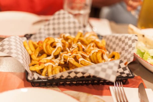 closeup of a platter of french fries on a restaurant table - junk food stock pictures, royalty-free photos & images