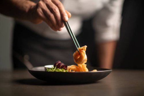 closeup of male chef in restaurant decorates the meal - food stock pictures, royalty-free photos & images