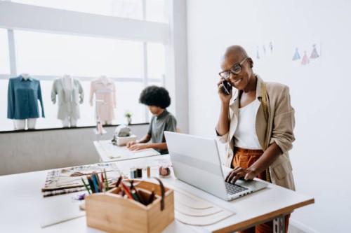 clothing store manager talking on smartphone - fashion stock pictures, royalty-free photos & images