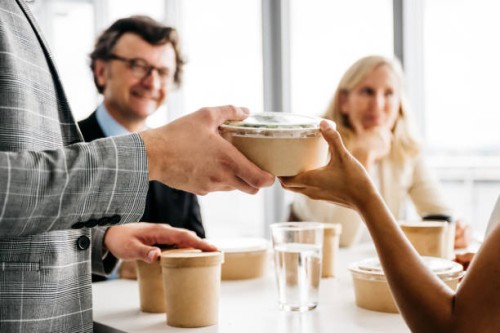 co-workers enjoying a take-away meal at lunch break - junk food stock pictures, royalty-free photos & images