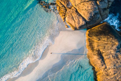 coastline aerial photograph of aquamarine ocean and man walking along white sandbar beach - travel stock pictures, royalty-free photos & images