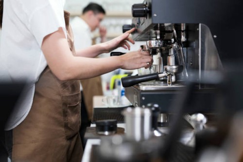 coffee shop franchise solution. side view of asian female barista making brewed coffee for serving to customer order. - junk food stock pictures, royalty-free photos & images