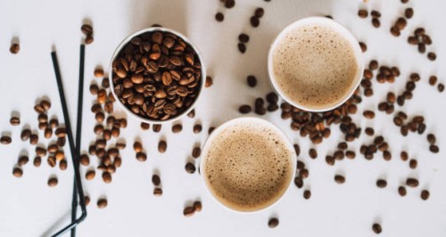 coffee to go in tray on white table with coffee beans and straws - junk food stock pictures, royalty-free photos & images