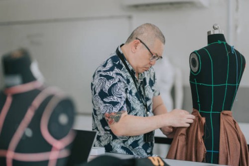 college fashion design lecturer showing his students on the fashion design clothing pin on mannequin - fashion stock pictures, royalty-free photos & images
