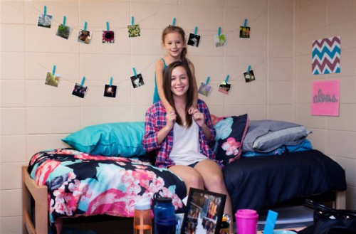 college student smiling with sister in dormitory room - home decoration stock pictures, royalty-free photos & images