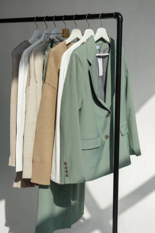 colorful beautiful clothes hanging on hangers on a rail in a store. shopping concept and sale of clothes - fashion stock pictures, royalty-free photos & images