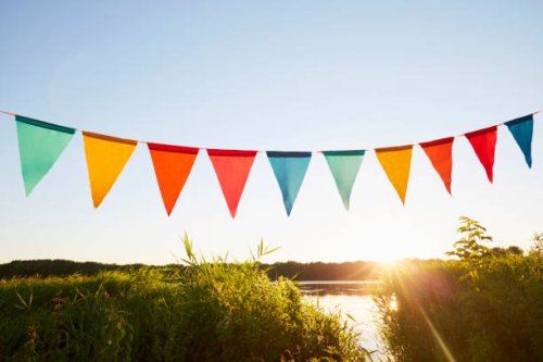 colorful pennant flags for party decoration at lake against sky - garden decoration stock pictures, royalty-free photos & images