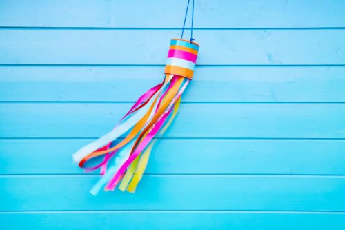 colorful self-made wind chime hanging at a blue wooden wall - garden decoration stock pictures, royalty-free photos & images