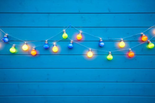 colorful string lights for party decoration at a blue painted wooden wall - garden decoration stock pictures, royalty-free photos & images