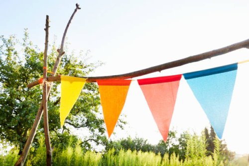 colourful bunting flags/ pennant chain for party decoration in a garden against sky - garden decoration stock pictures, royalty-free photos & images