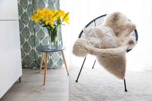 comfortable chair with sheepskin and cushion - home decoration stock pictures, royalty-free photos & images