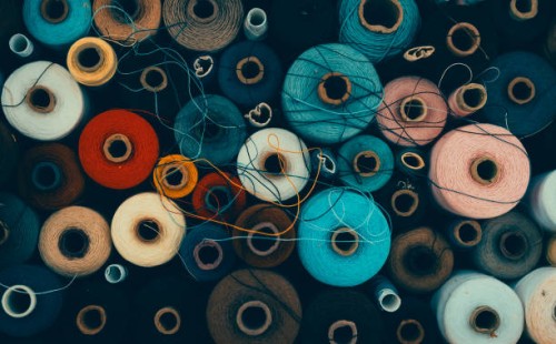 composition of sewing spools with colorful vibrant threads from above - fashion stock pictures, royalty-free photos & images