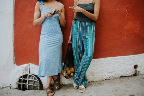 conceptual image of two fashionable females against a red wall in positano, italy - fashion stock pictures, royalty-free photos & images